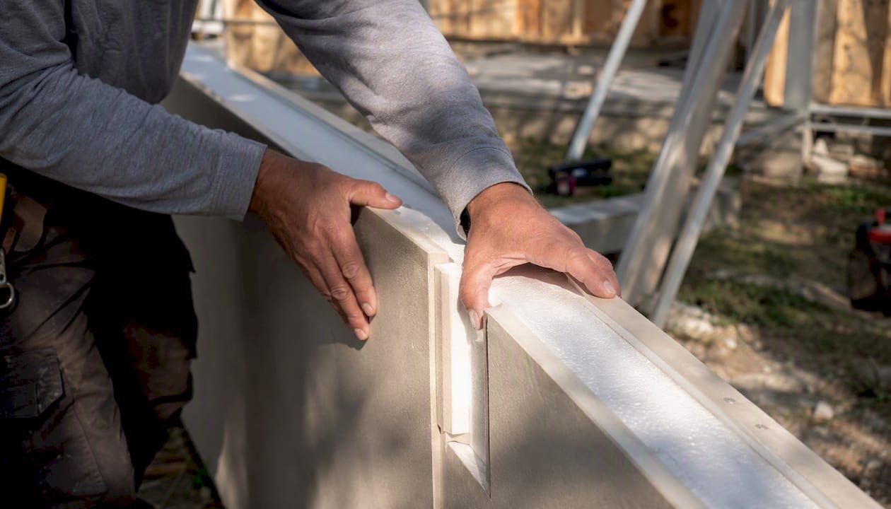 Hands assembling insulated panel of modular home